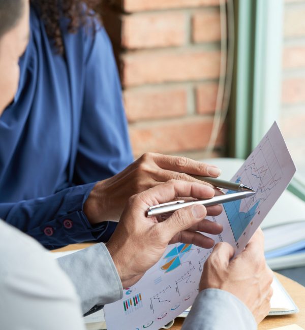 Close-up image of colleagues analyzing information in business document